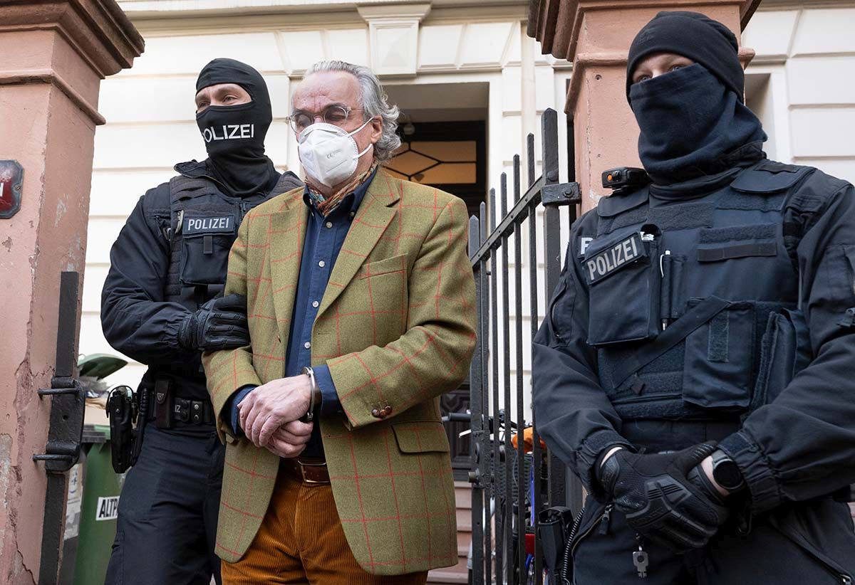 Originalbild: Bei einer Razzia gegen sogenannte «Reichsbürger» am 7. Dezember 2022 in Frankfurt/Main führen vermummte Polizisten Heinrich XIII Prinz Reuss zu einem Polizeifahrzeug. Foto: Keystone-SDA, dpa, Boris Roessler Originalbild: Bei einer Razzia gegen sogenannte «Reichsbürger» am 7. Dezember 2022 in Frankfurt/Main führen vermummte Polizisten Heinrich XIII Prinz Reuss zu einem Polizeifahrzeug. Foto: Keystone-SDA, dpa, Boris Roessler