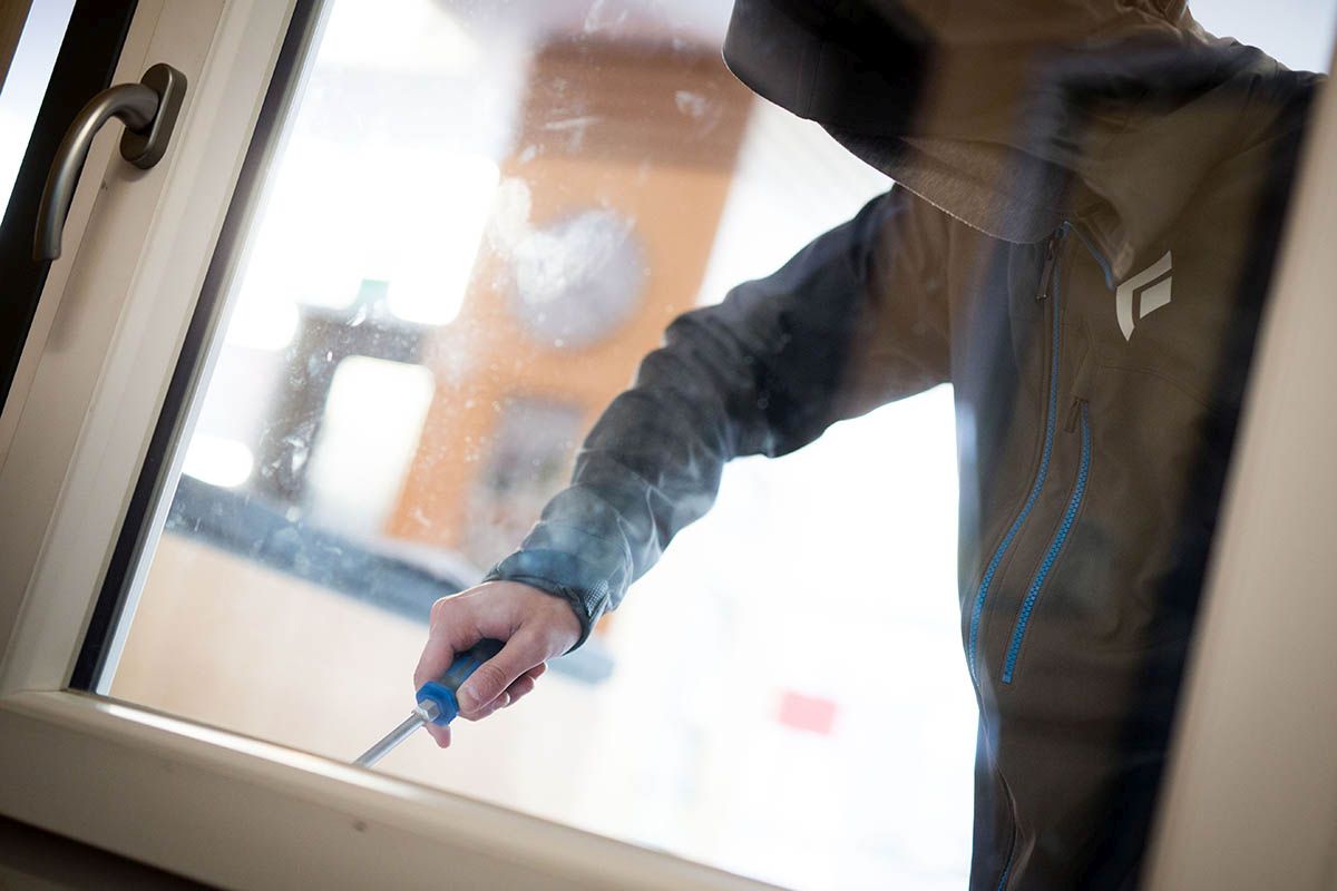 Ein Mann demonstriert in der polizeilichen Beratungsstelle, wie einfach es für einen Einbrecher wäre, mit Hilfe eines stabilen Schraubenziehers ein geschlossenes Fenster von aussen zu öffnen (Aufnahme vom 10. April 2015). Foto: Keystone-SDA / dpa / Frank Rumpenhorst