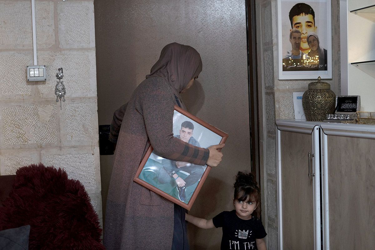 Maysoon Manasra trägt am 8. November 2022 in ihrer Wohnung in Ost-Jerusalem ein Porträt ihres Sohnes Ahmed Manasra, der im Alter 13 Jahren von Israel inhaftiert wurde. Er war wegen versuchten Mordes zu neuneinhalb Jahren Gefängnis verurteilt worden, nachdem sein älterer Cousin zwei Israelis erstochen hatte. Der damals 13-jährige palästinensische Junge, dessen Fall 2015 zum Brennpunkt eines israelisch-palästinensischen Konflikts wurde, ist jetzt ein Mann, der in Einzelhaft sitzt und mit Schizophrenie zu kämpfen hat. Foto: Keystone-SDA/AP Photo/Maya Alleruzzo