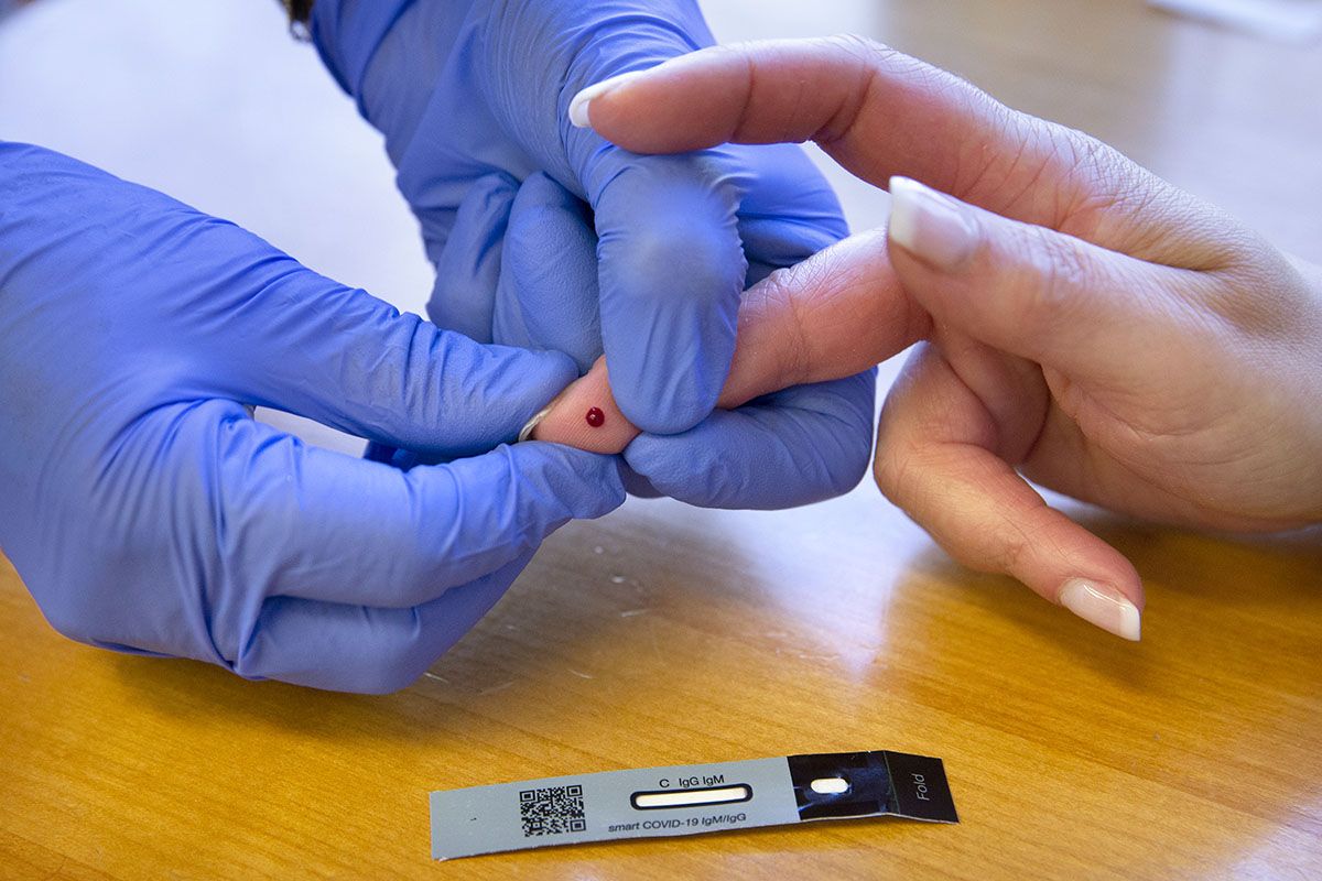 Eine Apothekerin entnimmt am 3. Mai 2021 in Genf dem Finger einer Frau einen Tropfen Blut, um mit einem schnellen Screening-Test Antikörper gegen das Sars-CoV-2 nachzuweisen. Foto: Keystone-SDA / Salvatore Di Nolfi
