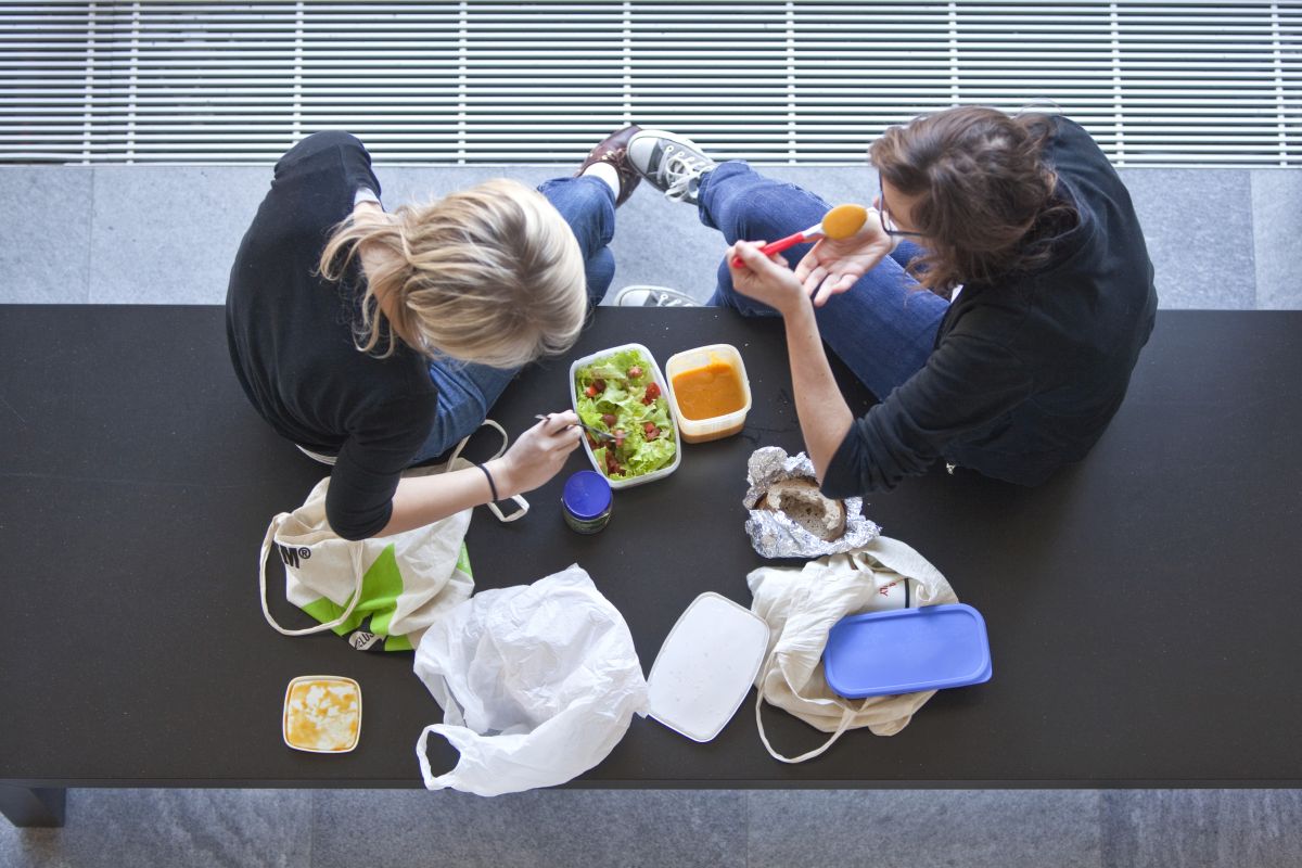 81445064 – Deux étudiantes se restaurent sur un banc du bâtiment « Pérolles II » de la Faculté des sciences économiques et sociales de l'Université de Fribourg. Photo: KEYSTONE / Martin Rütschi