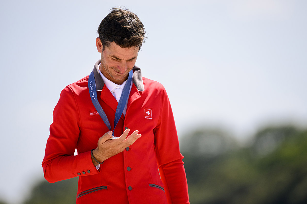 623042339 - Steve Guerdat (sur Dynamix De Belheme) célèbre sa médaille d’argent le 6 août 2024 lors de la cérémonie protocolaire de la finale individuelle de saut d’obstacles aux JO de Paris. Photo: KEYSTONE/ Laurent Gilliéron 623042339 - Steve Guerdat (sur Dynamix De Belheme) célèbre sa médaille d’argent le 6 août 2024 lors de la cérémonie protocolaire de la finale individuelle de saut d’obstacles aux JO de Paris. Photo: KEYSTONE/ Laurent Gilliéron